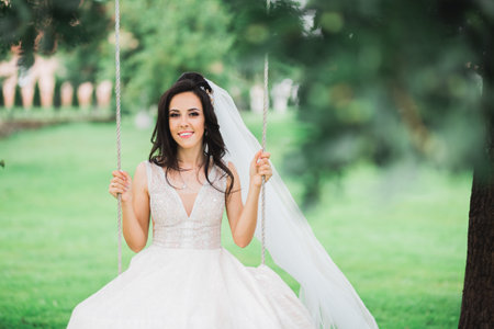 Beauty portrait of bride wearing fashion wedding dress with feathers with luxury delight make-up and hairstyleの写真素材