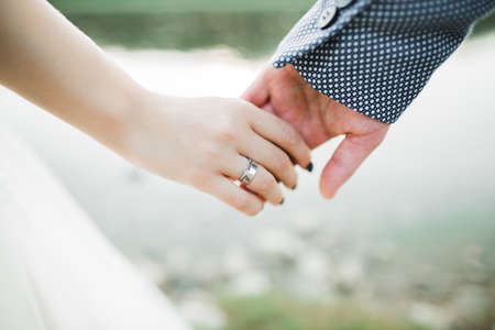 Wedding couple holding hands, groom and bride together on wedding dayの写真素材