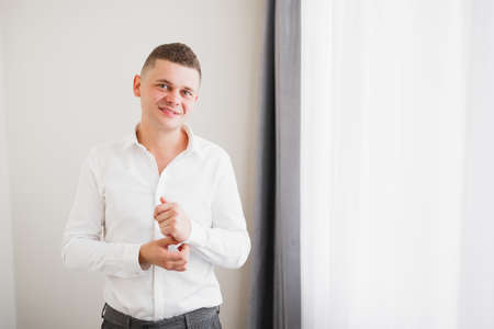 Young handsome man relaxing at his apartment in a hotel after business meetingの写真素材
