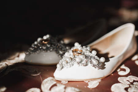 Beautiful toned picture with wedding rings and wedding shoesの写真素材