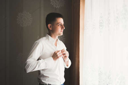 Beautiful man, groom posing and preparing for weddingの写真素材