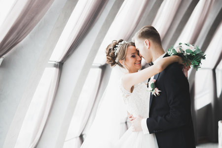 Perfect couple bride, groom posing and kissing in their wedding dayの写真素材