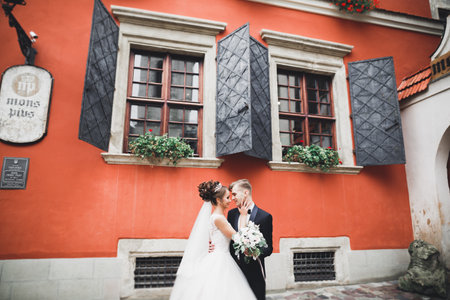 Perfect wedding couple holding luxury bouquet of flowersの写真素材