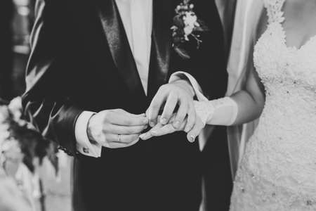 Bride and groom exchanging wedding rings. Stylish couple official ceremonyの写真素材