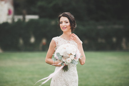 Beautiful bride posing in wedding dress outdoorsの写真素材