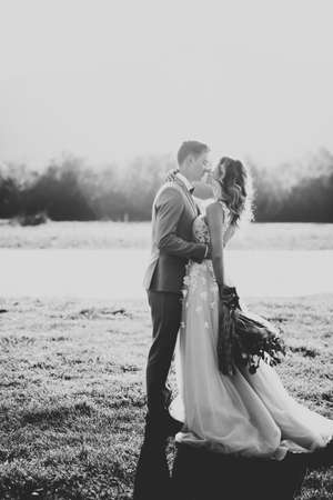 Wedding couple, groom and bride hugging, outdoor near riverの写真素材