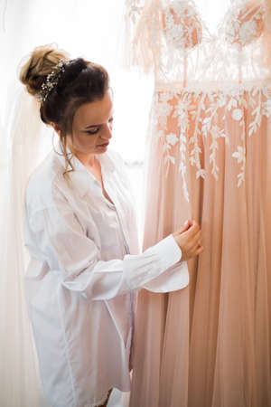 Beautiful bride wearing fashion wedding dress with feathers with luxury delight make-up and hairstyle, studio indoor photo shootの写真素材