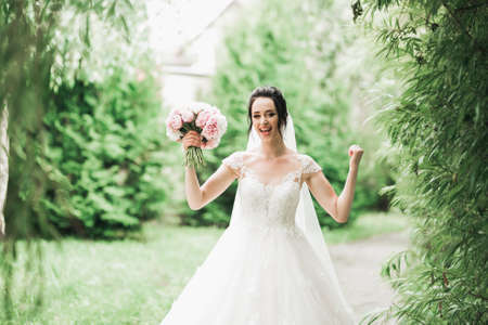 Luxury wedding bride, girl posing and smiling with bouquetの写真素材