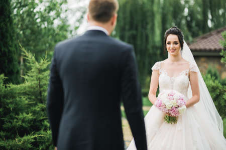 Gorgeous happy couple standing close to each other and looking in eyes