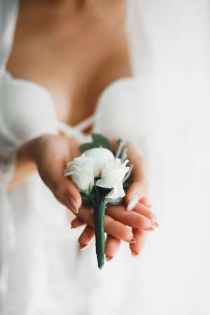 Beautiful luxury bride in elegant white dress holds bouquet of flowers in the hands