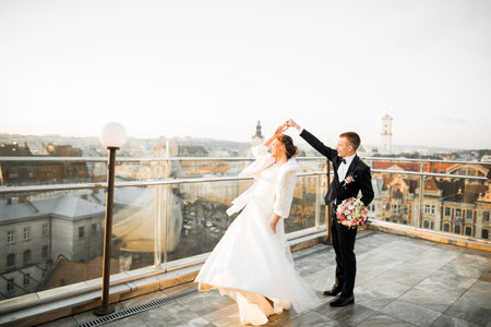 Beautiful wedding couple dancing on a balconyの写真素材