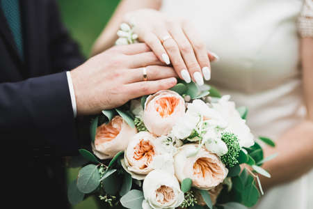 Perfect wedding couple holding luxury bouquet of flowersの写真素材