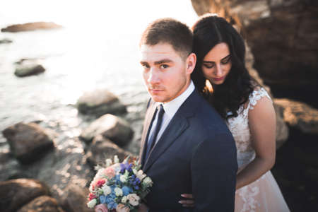 Happy and romantic scene of just married young wedding couple posing on beautiful beachの写真素材