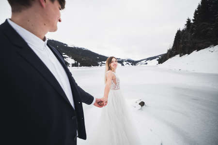 Woman with beautiful hair discovering beautiful places holding boyfriends hand. Follow meの写真素材