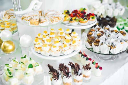 Delicious sweets on wedding candy buffet with desserts, cupcakesの写真素材