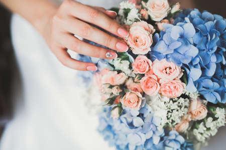 Bride holding big and beautiful wedding bouquet with flowersの写真素材