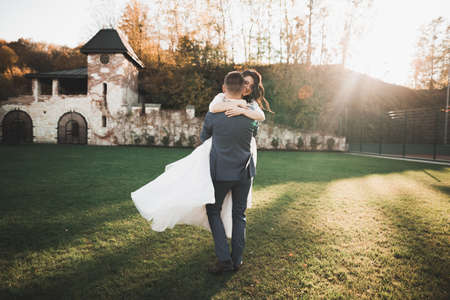 Perfect couple bride, groom posing and kissing in their wedding dayの写真素材