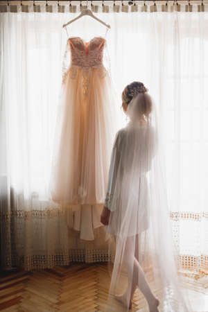 Beautiful bride wearing fashion wedding dress with feathers with luxury delight make-up and hairstyle, studio indoor photo shootの写真素材