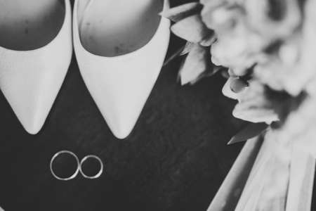 Beautiful toned picture with wedding rings and wedding shoesの写真素材