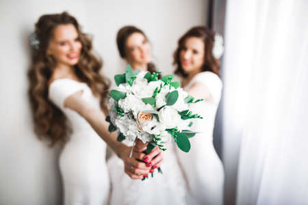 Bride with bridesmaids holding wonderful luxury wedding bouquet of different flowers on the wedding dayの写真素材