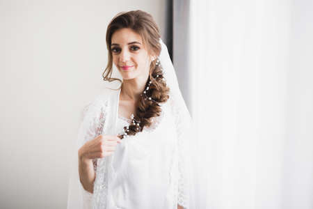 Beautiful bride wearing fashion wedding dress with feathers with luxury delight make-up and hairstyle, studio indoor photo shootの写真素材