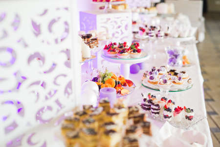 Delicious and tasty dessert table with cupcakes shots at reception closeupの写真素材