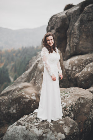 Beauty woman, bride with perfect white dress background mountainsの写真素材