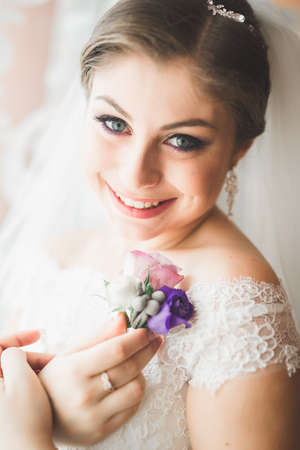 Beautiful bride wearing fashion wedding dress with feathers with luxury delight make-up and hairstyle, studio indoor photo shootの写真素材