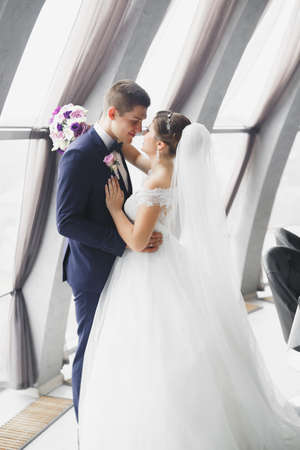 Perfect couple bride, groom posing and kissing in their wedding dayの写真素材