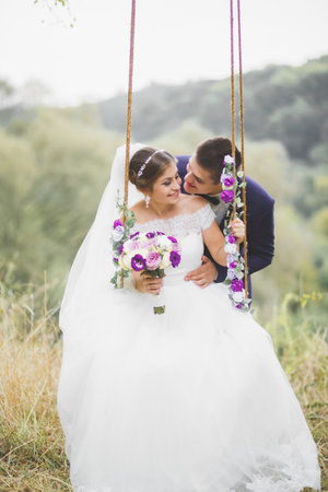 Perfect couple bride, groom posing and kissing in their wedding dayの写真素材