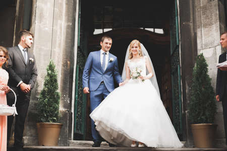 Lovely happy wedding couple, bride with long white dress posing in beautiful cityの写真素材