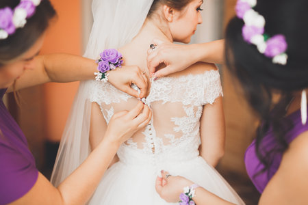 Beautiful bride wearing fashion wedding dress with feathers with luxury delight make-up and hairstyle, studio indoor photo shootの写真素材
