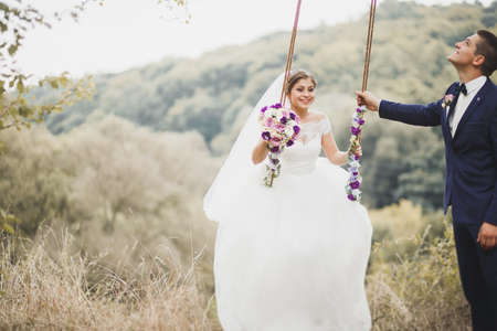 Perfect couple bride, groom posing and kissing in their wedding dayの写真素材