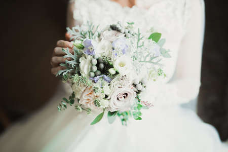 Bride holding big and beautiful wedding bouquet with flowersの写真素材