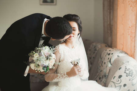 Perfect couple bride, groom posing and kissing in their wedding dayの写真素材