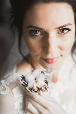 Gorgeous bride in robe posing and preparing for the wedding ceremony face in a roomの写真素材