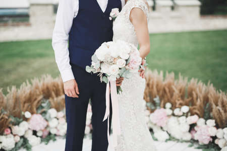 Lovely happy wedding couple, bride with long white dress posing in beautiful cityの写真素材