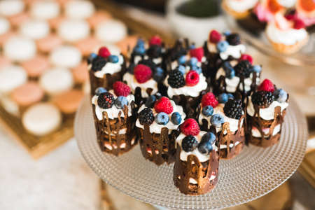 Delicious and tasty dessert table with cupcakes shots at reception closeupの写真素材