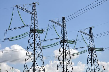 Power transmission lines on the background of the blue sky and the clouds