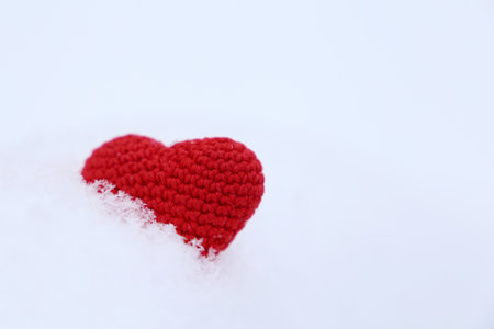 Valentine heart in a snow. Red knitted symbol of love, background for winter holiday
