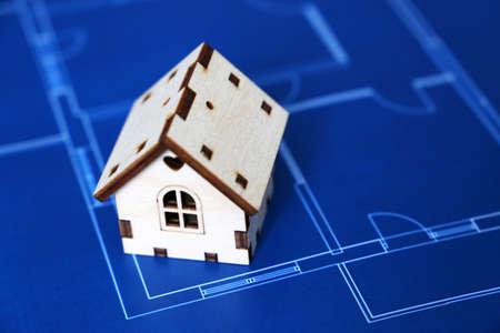 Wooden house on background of apartment plan. House drawing, purchase of real estateの写真素材