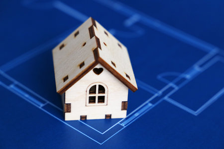 Wooden house on background of apartment plan. House drawing, purchase of real estateの写真素材