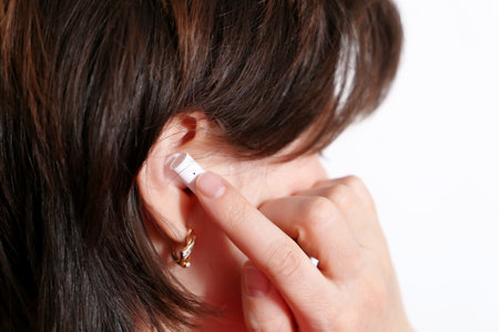 Woman touching wireless earphone in the ear. Headset, listening to music and voice call concept