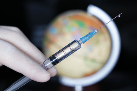 Vaccination in the world, doctor hand with syringe on globe background. Concept of health care during  pandemicの写真素材