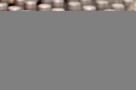 Bottles of white wine in a row, selective focus. Liquor store, wine productionの写真素材