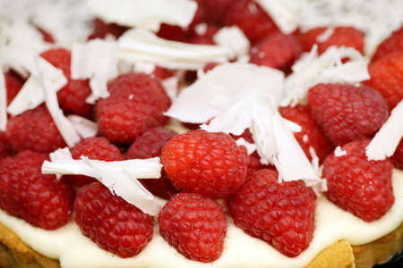 Raspberry pie with white grated chocolate, cream and fresh berriesの写真素材