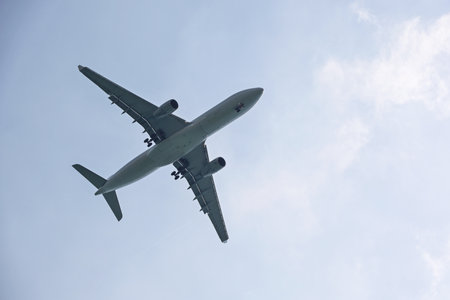 Airplane flying in sky with white clouds. Passenger plane at flightの写真素材