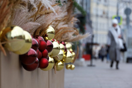 New Year decorations in city, golden and red Christmas balls on a street on blurred people backgroundの写真素材