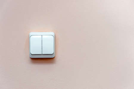 white electric switch on pink wall