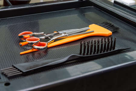 workplace of the hairdresser. comb, scissors, hair coloring brush on rubber Mat
